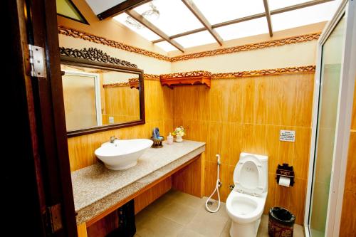 皮皮岛Paradise Pearl Bungalows的一间带水槽、卫生间和镜子的浴室