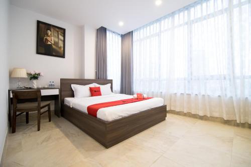 胡志明市AHA Residence Dien Bien Phu near Hang Xanh Binh Thanh的一间卧室配有一张床、一张书桌和一个窗户。