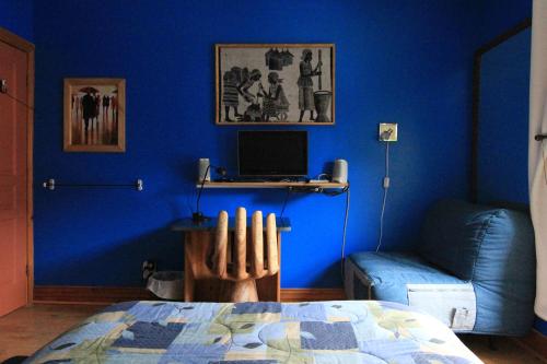 蒙特利尔伊特拉佩乌住宿加早餐旅馆的蓝色的客房配有一张床和一张带电脑的书桌