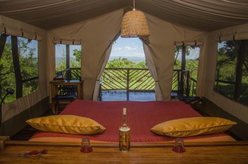 AitongMara Siria Tented Camp & Cottages的一个带窗户的帐篷内一间卧室,配有一张床