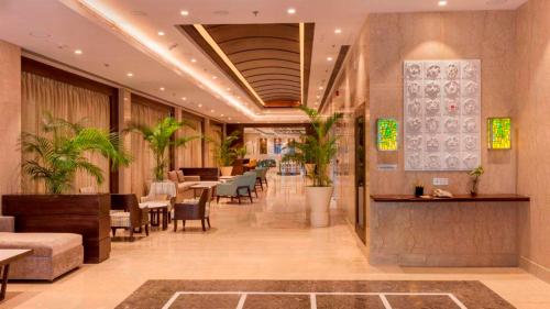 勒克瑙Lemon Tree Hotel Lucknow的一个带桌椅的餐厅的大堂