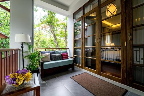 清迈Villa Klang Wiang的门廊上设有长凳和桌子的屏风
