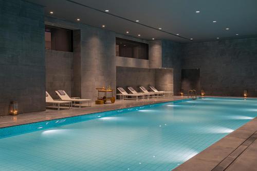 上海上海素凯泰酒店的一个带椅子和桌子的大型游泳池