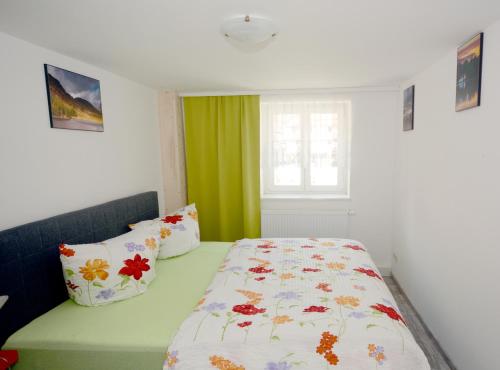 ElbeGrafenblick, Ferienwohnung mit Aussicht!的一间卧室配有一张带花卉棉被的床和窗户。