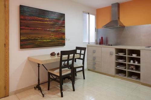 阿利坎特阿拉莫酒店的厨房配有桌子和两把椅子以及一幅画