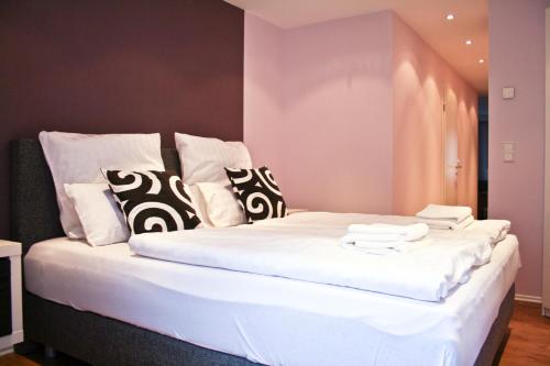巴德塞尔佐根伊丽莎白小屋宾馆的一张白色大床,配有黑白枕头