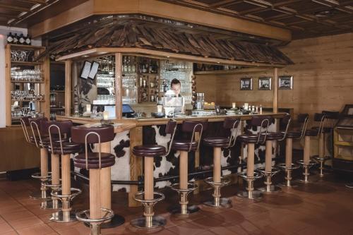 施伦斯阿卡缇弗阿尔彭罗斯温泉酒店的餐厅内带皮凳的酒吧