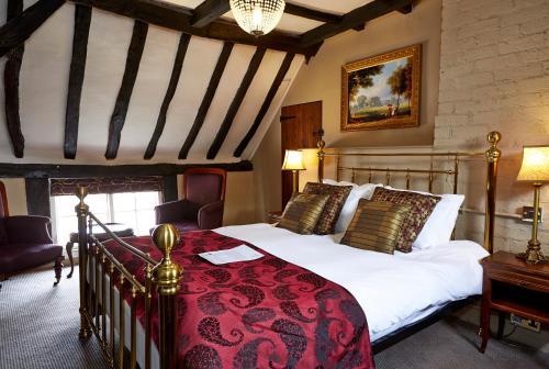 科尔斯希尔The Coleshill by Greene King Inns的一间卧室配有一张带红色毯子的大床