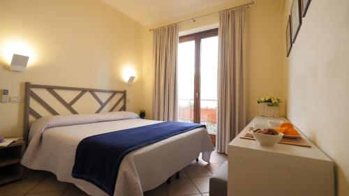 卡斯蒂里昂纳·德拉佩Residenza Turistico Alberghiera Corallo的酒店客房设有床和窗户。