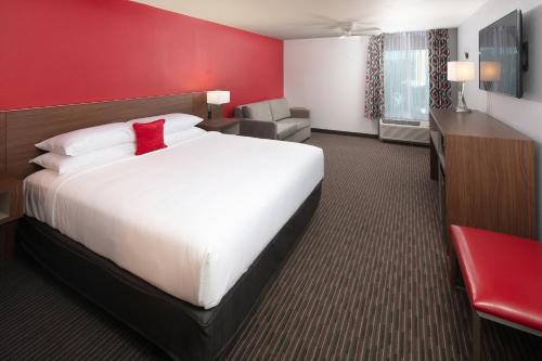 基西米Red Lion Hotel Orlando Lake Buena Vista South- Near Disney的酒店客房设有一张大床和红色的墙壁。