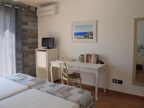 圣何塞Casa Agua Marina的一间卧室配有两张床、一张桌子和一台电视。