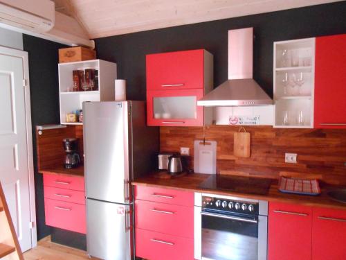 AablaAablaranna Puhkemaja的一间带红色橱柜和冰箱的厨房