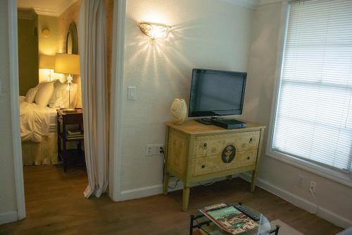 奥兰多Winter Park charm的一间房间,配有带床铺的梳妆台上配有电视