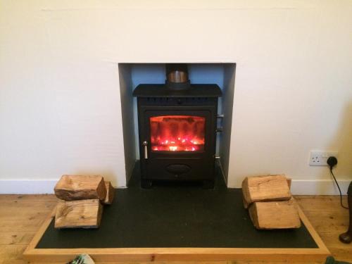 Isle of GighaArdminish House Gigha的配有两个木柴的房间的炉灶