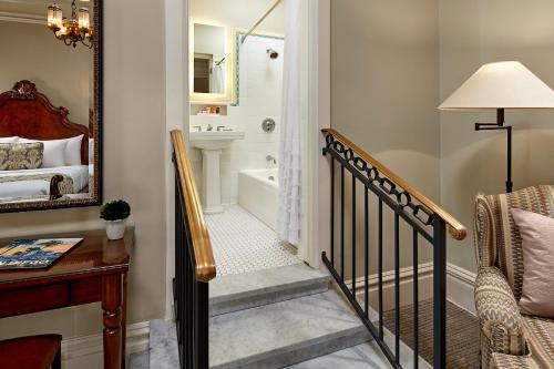 圣地亚哥格罗利埃塔湾旅馆的通往带浴缸和盥洗盆的浴室的楼梯