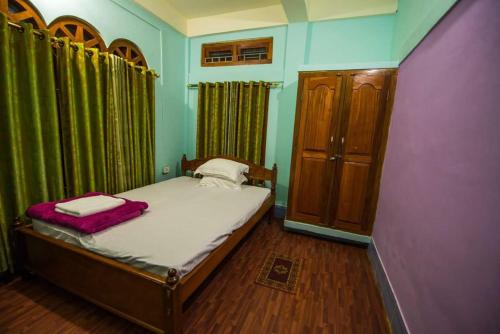 帕西加特VAMOOSETRAIL PASIGHAT(1)的一间小卧室,配有床和绿色窗帘