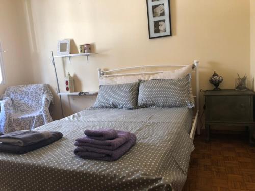雅典Vintage apartment , 700m from metro的一间卧室配有一张床,上面有两条毛巾