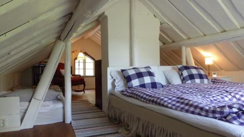 卢恩斯基尔Cottage - Majviken的阁楼卧室配有床