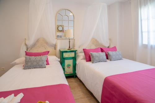 马拉加A&S Apartamentos Malaga的粉红色和白色的客房内的两张床