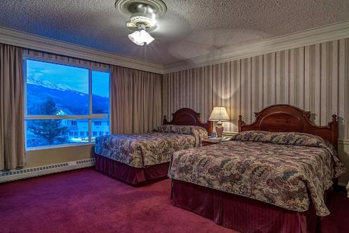 贾斯珀阿萨巴斯卡酒店的酒店客房设有两张床和大窗户。