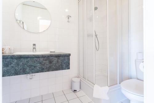 布兰肯贝赫Avenue Hotel by F-Hotels的带淋浴、盥洗盆和卫生间的浴室