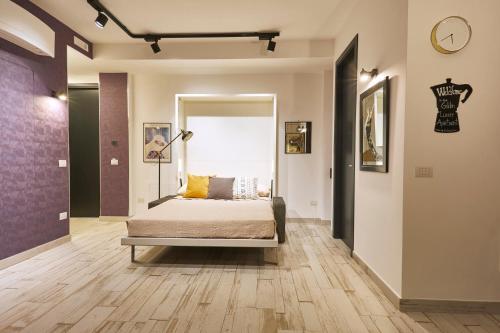 那不勒斯Luxury Experience | WelcHome Napoli的卧室配有一张床,墙上挂着一个钟