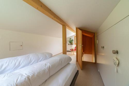 维尔德豪斯Steinrüti的一间卧室设有两张床,一扇门通往房间