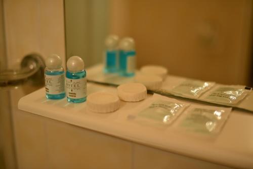 奥恰基夫Foton Hotel & Restaurant的浴室柜台配有瓶装气味器和镜子