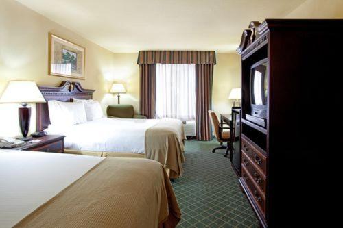 西门罗西门罗智选假日酒店套房的酒店客房设有两张床和电视。