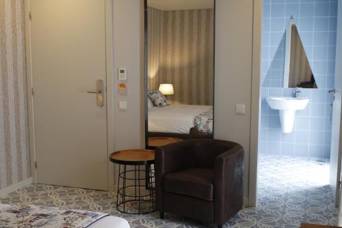 普拉亚达维多利亚Royal Beach Hostel的一间卧室配有镜子、椅子和一张床