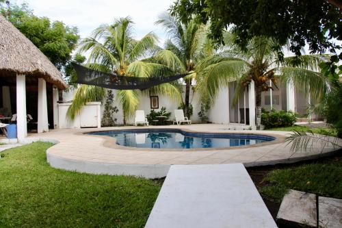 El ConacasteCasa San José的棕榈树房子后院的游泳池
