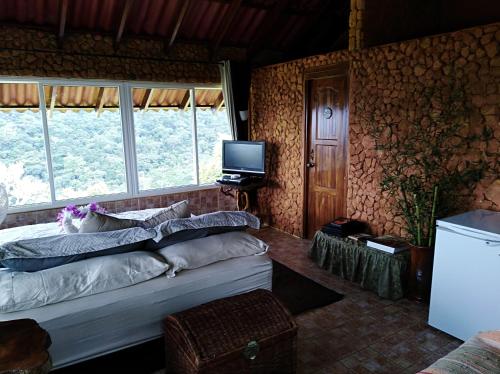 塞罗阿苏尔Mandalas Ecolodge的一间卧室配有一张床和一台电视