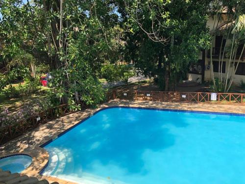 马利西亚斯Linda Casa Condomínio Maresias的一座大蓝色游泳池,位于房子前