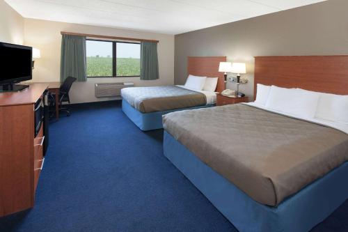 Webster CityAmericInn by Wyndham Webster City的酒店客房设有两张床和一台平面电视。