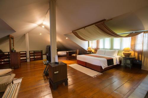 清迈清迈帝国度假村&运动俱乐部的一间卧室配有一张床、一张桌子和一张四柱床。