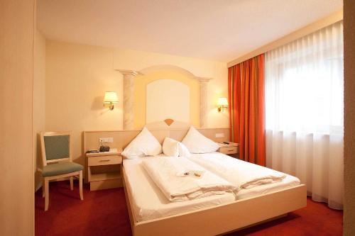 朗根费尔德拉维塔旅馆的卧室配有床、椅子和窗户。