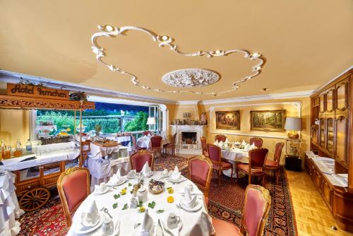 美因塔尔伊姆逊酒店的餐厅配有白色的桌椅和吊灯