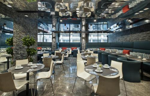 卡萨布兰卡ODYSSEE Boutique Hotel Casablanca的餐厅设有桌椅和窗户。