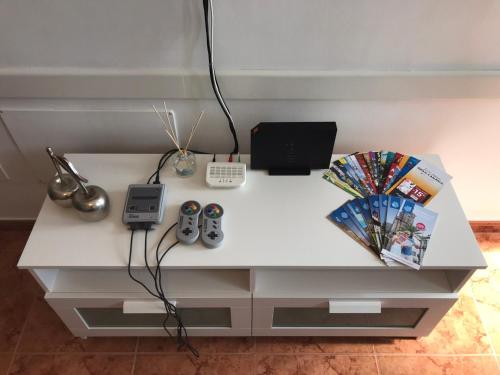 阿里纳加Apartamento Allegra的一张带两个遥控器和一台笔记本电脑的白色书桌