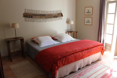 贝济耶Domaine de Manteau-Bleu的一间卧室配有一张带红色毯子的床
