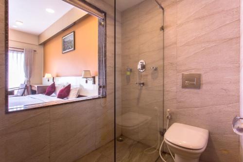 博卡拉女王公园酒店的带淋浴和卫生间的浴室以及一间卧室。