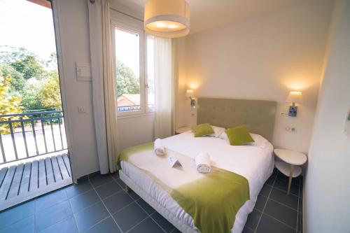 圣特罗佩Lou Riou Village Vacances的一间卧室设有一张大床和大窗户