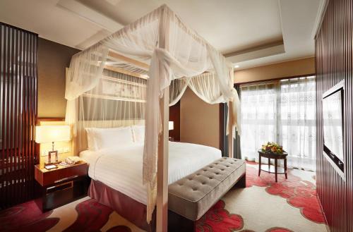 明斯克明斯克北京饭店的一间卧室设有天蓬床和窗户。
