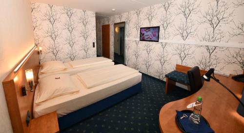 格尔林根斯图加特-格尔林根卓悦坦根斯酒店的配有一张床和一张书桌的酒店客房