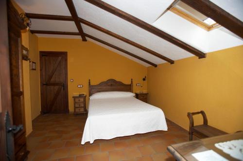 埃尔博斯克波萨达圣安东尼奥酒店的卧室配有一张白色床,位于黄色的墙壁上