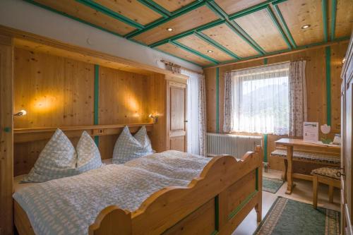 瓦尔赫湖Steindlhof in Walchsee的一间卧室设有一张床和木制天花板