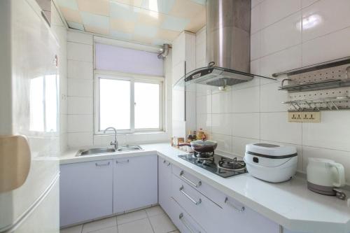 武汉武汉市武昌区·武昌江滩·路客精品公寓·00139250的白色的厨房设有水槽和炉灶。