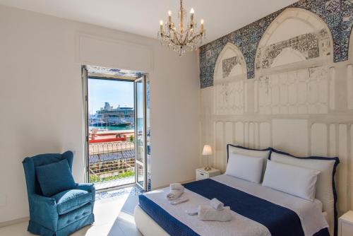 萨莱诺Relais Mareluna - Luxury Apartments的卧室配有床、椅子和窗户。