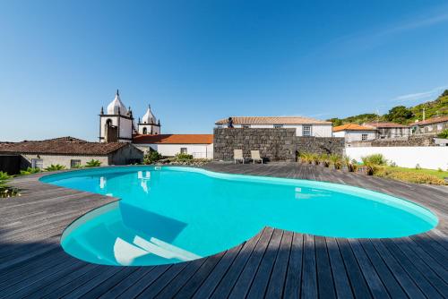 Calheta de NesquimT1 Casa das Pereiras的一座游泳池位于甲板上,建筑背景