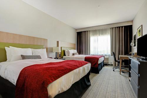 休斯顿Country Inn & Suites by Radisson Houston Westchase-Westheimer的酒店客房配有两张床和一张书桌
